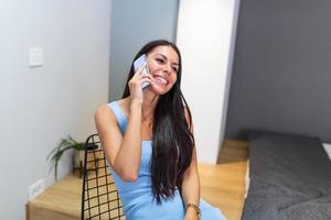 Close up Young Woman Talking to Someone on her Mobile Phone While Looking Into the Distance with Happy Facial Expression. photo