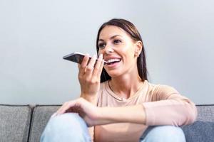 Close up woman hold smart phone talking on speakerphone through microphone with client, using translator application, internet services through virtual assistant or record audio message concept photo