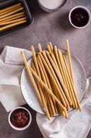 Crispy toasted sweet straws with berry jam on a plate for dessert. Top and vertical view photo
