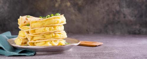 Kystyby - a thin flatbread filled with mashed potatoes and onions on a plate. Web banner photo