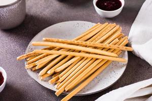 Crispy toasted sweet straws with berry jam on a plate for dessert. photo