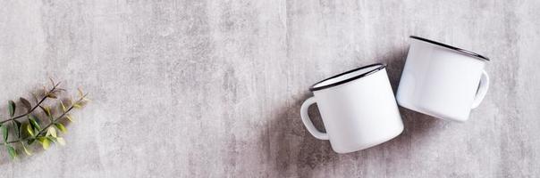 White empty metal mug on gray background for web banner. Top view photo