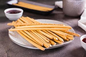 Crispy bakery straws with berry filling on a plate for dessert. photo