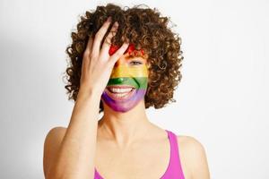 Smiling woman with face painted in rainbow colors photo