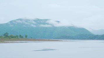 el atmósfera a lo largo el represa tenido corrientes y montañas con nubes Moviente en el Mañana. video