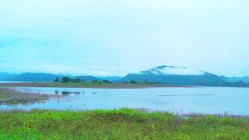 de atmosfär längs de damm i de morgon- fick syn på de flod och grön bergen i de bakgrund. video