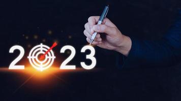 Business target and goal 2023 icon, hand pointing holding 2023 virtual screen, Start new year 2023 with a goal plan, action plan, strategy, new year business vision. photo