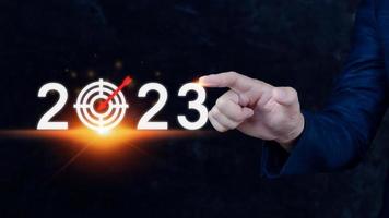 Business target and goal 2023 icon, hand pointing holding 2023 virtual screen, Start new year 2023 with a goal plan, action plan, strategy, new year business vision. photo