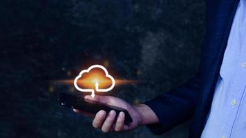 Businessman holding smartphone with virtual cloud computing to transfer database information upload, download application. technology business transformation concept. photo