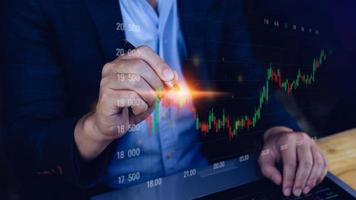 Businessman finger touch symbol stock graph and chart background, concept growth and development business investment, Stock market and strategy making market plan and stock market fluctuations photo