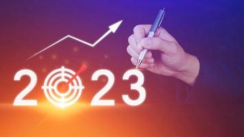 Business target and goal 2023 icon, hand pointing holding 2023 virtual screen and up arrow, Start new year 2023 with a goal plan, action plan, strategy, new year business vision. photo