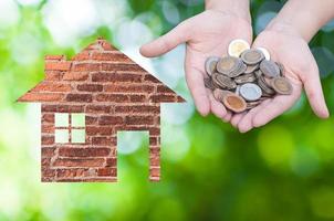 Coin Hand holding house icon in nature as symbol of mortgage,Dream house on nature background, isolated on white background photo