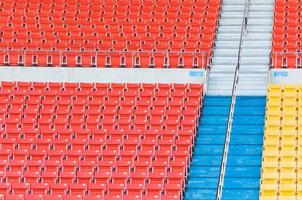 asientos vacíos de color naranja y amarillo en el estadio, filas de asientos en un estadio de fútbol foto