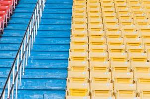 asientos vacíos de color naranja y amarillo en el estadio, filas de asientos en un estadio de fútbol foto