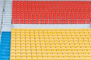 asientos vacíos de color naranja y amarillo en el estadio, filas de asientos en un estadio de fútbol foto