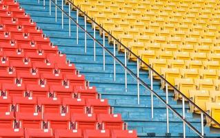 asientos vacíos de color naranja y amarillo en el estadio, filas de asientos en un estadio de fútbol foto