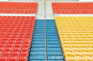 asientos vacíos de color naranja y amarillo en el estadio, filas de asientos en un estadio de fútbol foto