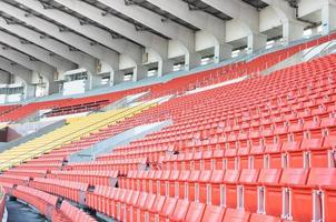 asientos vacíos de color naranja y amarillo en el estadio, filas de asientos en un estadio de fútbol foto