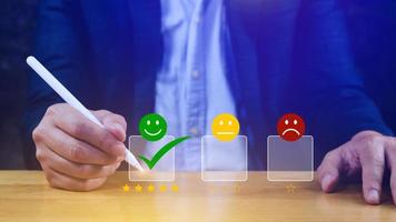 Businessman choosing happy smile face icon. feedback rating and positive customer review experience, satisfaction survey. mental health assessment. photo