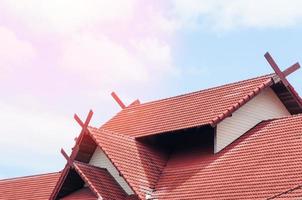 rojo techo casa con embaldosado techo en azul cielo foto