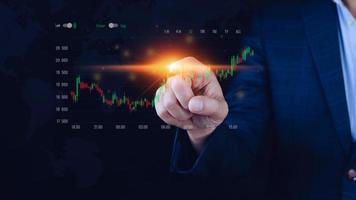 Businessman finger touch symbol stock graph and chart background, concept growth and development business investment, Stock market and strategy making market plan and stock market fluctuations photo