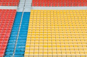 asientos vacíos de color naranja y amarillo en el estadio, filas de asientos en un estadio de fútbol foto