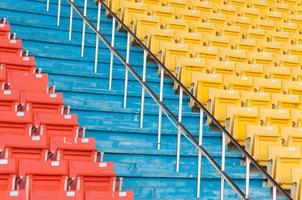 asientos vacíos de color naranja y amarillo en el estadio, filas de asientos en un estadio de fútbol foto