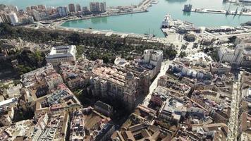 Malaga Cathedral against the city Port and seascape, Spain. Aerial wide pullback shot video