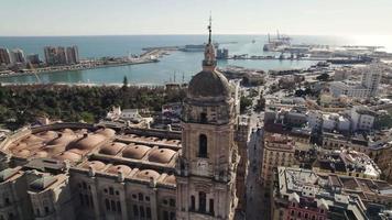 Malaga Cathedral of Incarnation with port in background, Spain. Aerial circling video