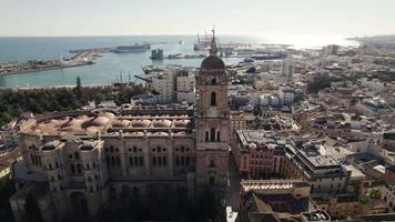 Aerial forward view of a side of cathedral with port in background. Malaga. Spain video