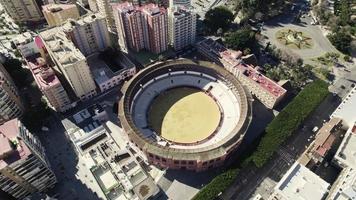 plein de toros la Malagueta, Malaga arena tegen stadsgezicht, Spanje. antenne kantelen omhoog schot video