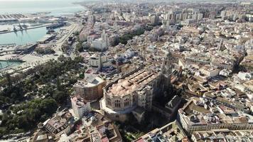 Cathedral of Incarnation in Malaga historic center with touristic port in background, Spain. Aerial top-down circling video