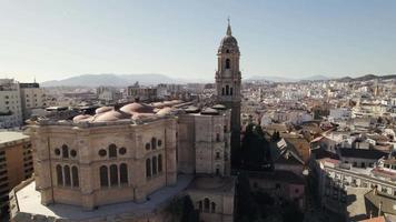 Malaga Cathedral against sprawling cityscape and port. Aerial view video