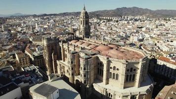Magnificent sun-drenched Malaga Cathedral standing watch over city. aerial video