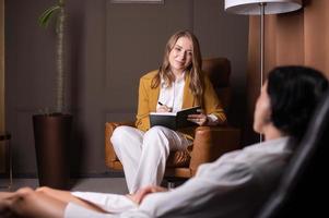 A young woman makes an entry in her diary and looks at the client photo