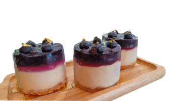 cheesecake med svart vinbär och blåbär sås på trä- tallrik på en transparent bakgrund png