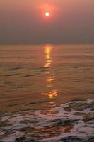 The sun is rising, the sun is bright, the morning sea at Cha-Am Beach photo