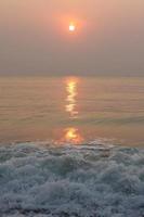 The sun is rising, the sun is bright, the morning sea at Cha-Am Beach photo