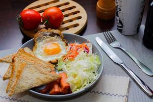 desayuno, frito huevos, frito embutido, vegetal ensalada y brindis en un marrón de madera mesa con café. foto