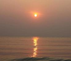 The sun is rising, the sun is bright, the morning sea at Cha-Am Beach photo