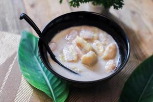 Banana in Coconut Milk on wood table Traditional dessert of asian, Thailand. photo