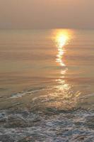 The sun is rising, the sun is bright, the morning sea at Cha-Am Beach photo