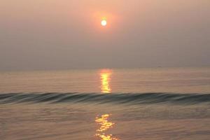 The sun is rising, the sun is bright, the morning sea at Cha-Am Beach photo