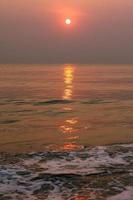 The sun is rising, the sun is bright, the morning sea at Cha-Am Beach photo