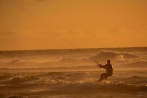 kitesurfer a puesta de sol foto