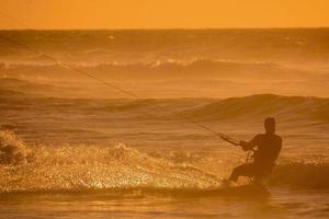 kitesurfer a puesta de sol foto