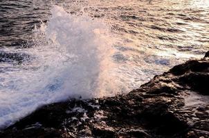 Wave crashing on the rocks photo