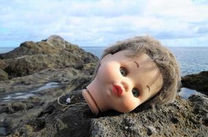 Toy doll laying on the rocks photo