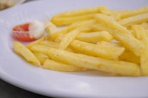 Close up photo of fried fries on white plate with mayo spicy sauce. The photo is suitable to use for Indonesia traditional food background, food poster and food content media.