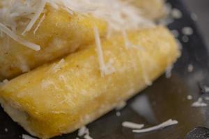 Close up photo of cheese fried banana with milk topping. The photo is suitable to use for Indonesia traditional food background, food poster and food content media.